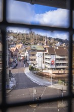 Town view visible through a grid with snow-covered streets and traditional buildings, car park ZOB