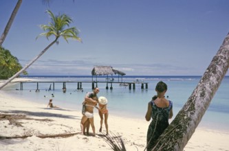 Tourists on sandy Buccoo beach Tobago, Trinidad and Tobago 1963 women playing around with man