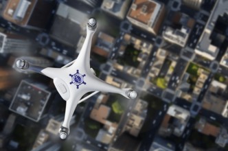 Top view of a police law enforcement drone UAV in flight over city streets and buildings