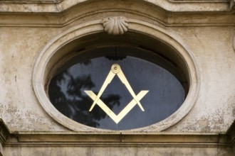 Close-up with compass and angle, two of the best-known symbols of Freemasonry on the lodge house,