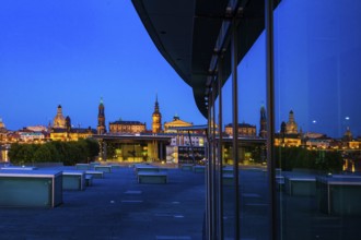 Reflection of the illuminated Old Town of Dresden in the façade of the Dresden Congress Centre