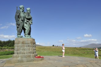 Tourists take photos in front of the Commando Memorial, bronze memorial by Scott Sutherland