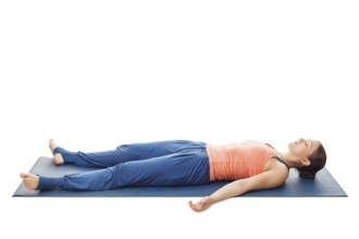 Woman relaxes in yoga asana Savasana, corpse pose isolated on white