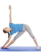 Yoga, young beautiful slender woman yoga instructor doing Triangle asana pose (utthita trikonasana)