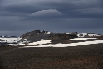 Snow-covered volcanic landscape with volcanic sand and petrified lava, crater of Askja volcano,