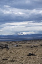 Volcanic landscape, barren landscape, snow-covered cloudy mountains in the back, Vatnajökull