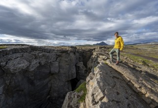 Tourist at a crevice, Grjótagjá, Myvatn, Iceland, Europe