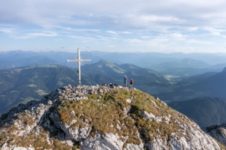 Two hikers at the summit, aerial view, evening mood in the mountains, summit cross of the