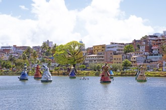 Sculptures of African deities on the natural spring lake Dique do Tororó, in the back typical