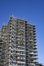 Scaffolded high-rise residential building with balconies and satellite dishes, Trabantenstadt