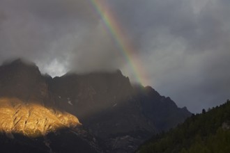 Rainbow over the mountains at Val Mingèr, Swiss National Park at Graubünden, Grisons in the Alps,