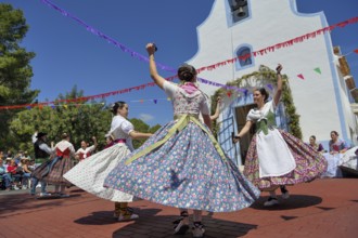 Women in traditional dress dance in front of the Ermita de San Vicent chapel, annual fiesta in