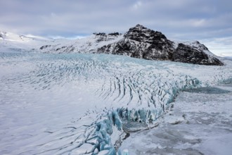 Snow-covered icebergs in the Fjallsarlon glacier lagoon, with the Öraefajökull glacier behind,