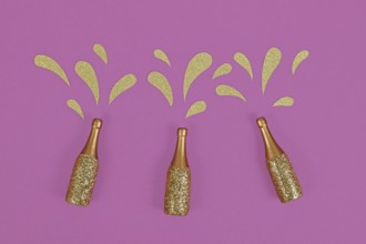 Three golden splashing Champagne bottles on purple background