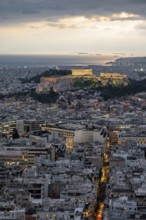 View over the sea of houses of Athens, illuminated Parthenon temple on the Acropolis, from Mount