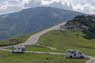 Motorhomes on the Transalpina high road at Papusa Peak, behind them the mountains in the Fagaras