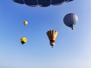 Four hot air balloons rise into the air, shuttlecock, advertising for BVB, view from below, mass