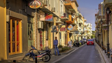 Venetian old town, old town street, moped, man, red car, lanterns, shop signs, colourful houses,