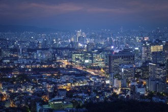 Seoul downtown cityscape illuminated with lights and Gyeongbokgung Palace in the evening view from