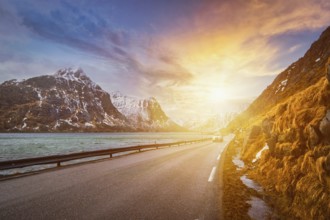 Car on road in Norwegian fjord on sunset. Lofoten islands, Norway, Europe