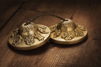 Tibetan Buddhist tingsha cymbals on wooden background