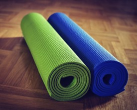 Vintage retro effect filtered hipster style image of Yoga mats on wooden floor