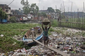 Construction workers transporting sand from a boat over a plank, Tel Ghat, Dhaka, Bangladesh, Asia