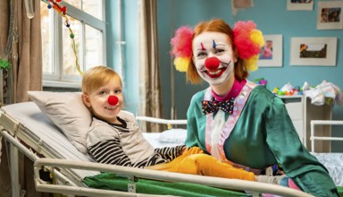 A female clown, a clinic clown, in mask, red nose and costume with a sick child in the clinic, AI