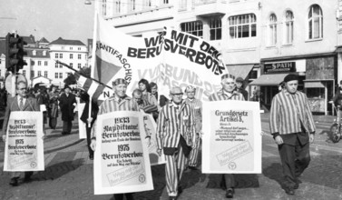 Nazi victims, some in concentration camp uniforms, demonstrated against the occupational bans