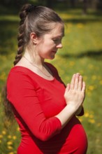 Pregnancy yoga exercise, pregnant woman doing asana Tadasana namaste -Mountain pose with salutation