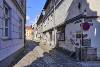 View through the hollow alley of Bechermacherstraße at the corner of Badenstraße, graffitied facade