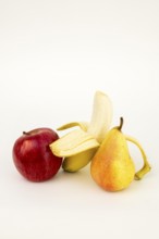 Half peeled banana with apple and pear, studio shot, white background, healthy food