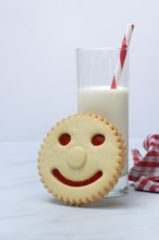 Pastry with smiley face and glass of milk