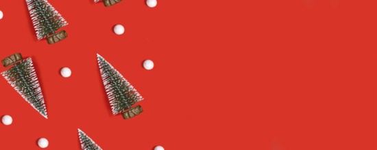 Red Christmas banner with trees and snowballs on red background with copy space