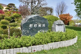 Freiburg, Germany, April 2022: Memorial stone with inscription in Japanese garden in public park