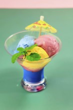 Homemade ice cream in a glass bowl with mint and umbrella, summer, Germany, Europe