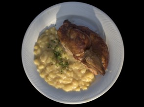 Half baked chicken with potato salad on a black background, Bavaria, Germany, Europe