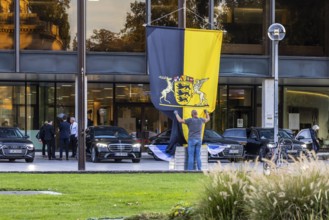 Flag with state coat of arms at the state parliament building, flag is taken down, behind it