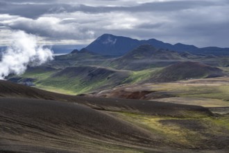 Volcanic landscape with colourful hills, steam of the Krafla geothermal power plant, geothermal