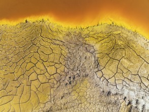 Cracked earth at the bank of the Rio Tinto (Red river) with its deep reddish hue due to oxidised