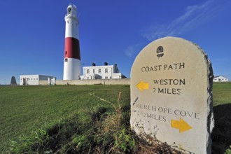 Portland Bill lighthouse and stone waymarker on the Isle of Portland along the Jurassic Coast,