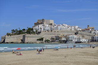 Bathers at the Playa de Peñíscola, beach, against the backdrop of the old town, Peñíscola, province