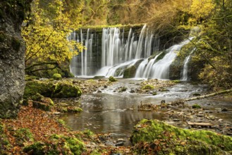 The Geratser waterfall in autumn. Moss-covered rocks and trees in autumn leaves. Gerats, Upper