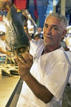 Brazilian man showing the large teeth of a black pacu or millstone tetra or tambaqui, Adolpho