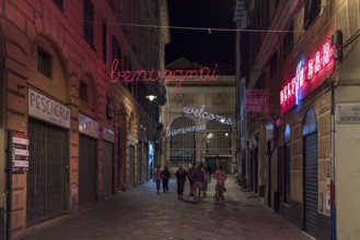 Illuminated evening advertising in the street leading to the market hall in the historic centre,