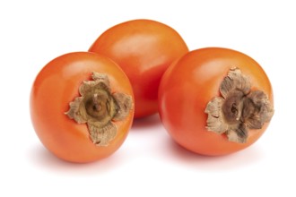 Three fresh ripe orange persimmons isolated on white background