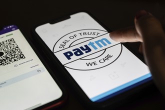 In this photo illustration, the Paytm logo and PhonePe QR code, is seen displayed on mobile phones