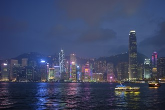 Hong Kong skyline cityscape downtown skyscrapers over Victoria Harbour in the evening illuminated