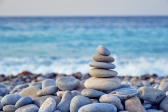 Zen meditation relaxation concept background, balanced stones stack close up on sea beach