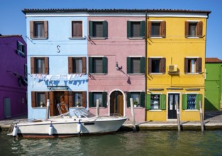 Colourful houses on the canal, canal with boats and colourful house facades, Burano Island, Venice,